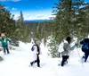 A group of hikers ascends a snowy slope under a bright sun
